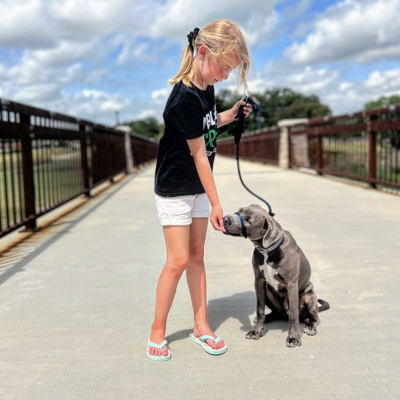 A girl training her puppy at a local Denton dog park.